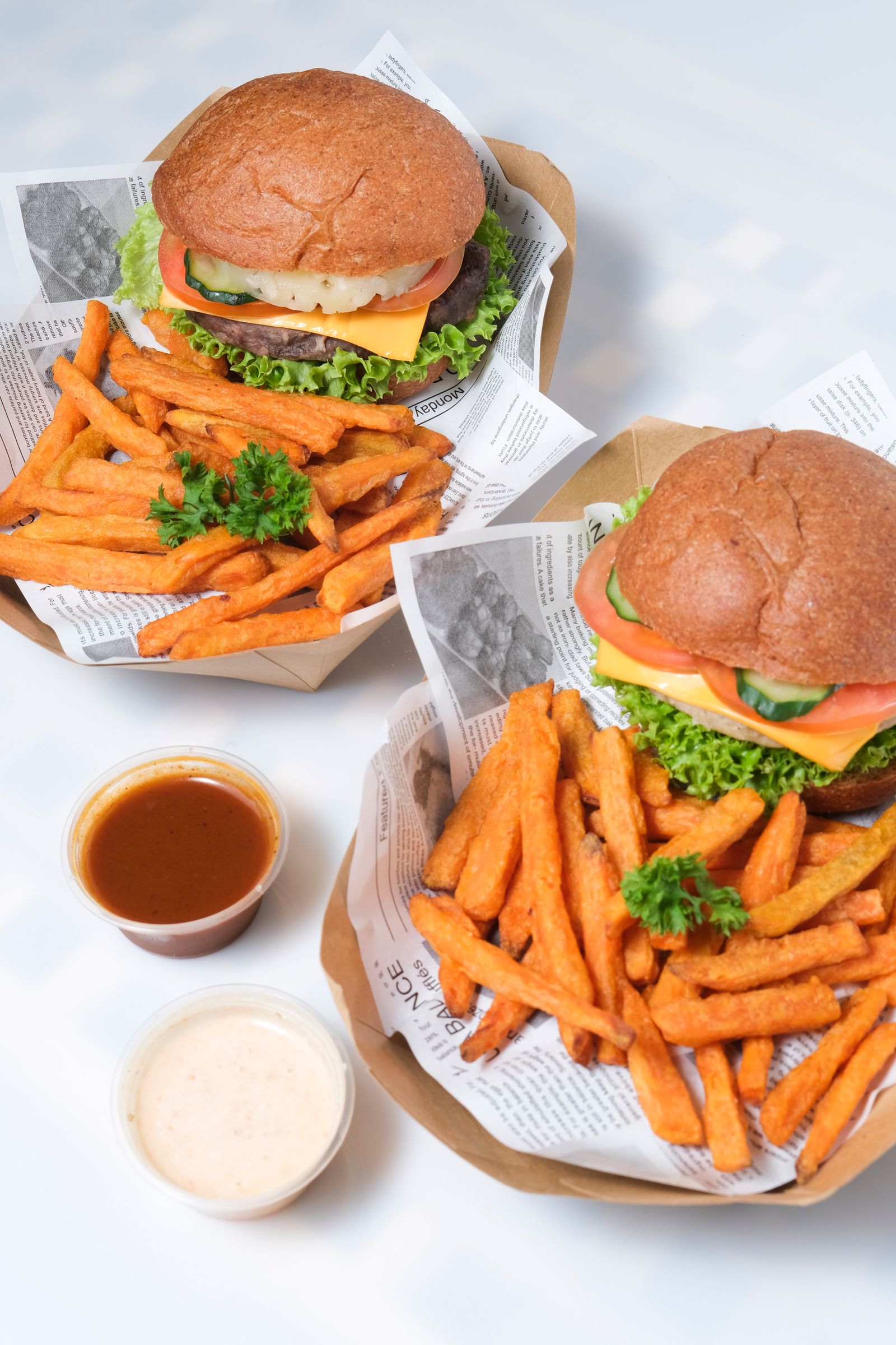 Dois combos de hambúrguer com batata em cestas de papel
